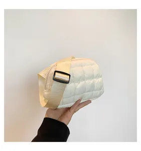 Dettaglio ravvicinato della borsa a tracolla trapuntata crema con texture soffice