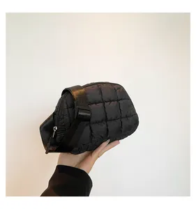 Dettaglio della borsa a tracolla trapuntata nera con texture a motivi a quadri cuciti
