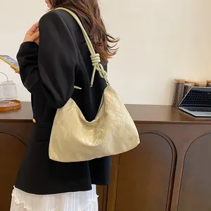 Chic beige hobo bag with a nautical rope knot strap for stylish daily commuting