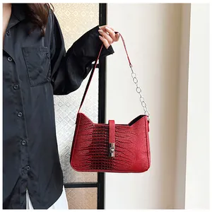 Detail of red faux crocodile leather shoulder bag with silver metallic twist lock closure
