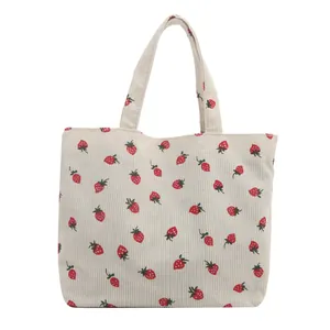 Chic corduroy tote bag featuring fresh strawberry prints and white canvas shoulder straps