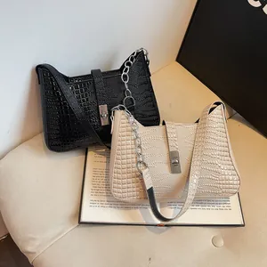 Detail of vintage crocodile pattern shoulder bags in black and beige with silver buckles