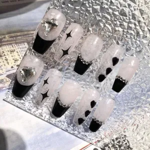 Detail of long trapezoid press-on nails with heart rhinestones and marble texture