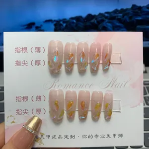 Close-up of black and pink gradient press-on nails with 3D gems and chains