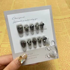 Detail of gothic coffin nails with grey heart rhinestones and silver cross chain accents