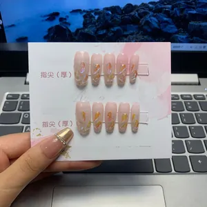 Detail of long ballerina press-on nails with pink gradient and crystal embellishments