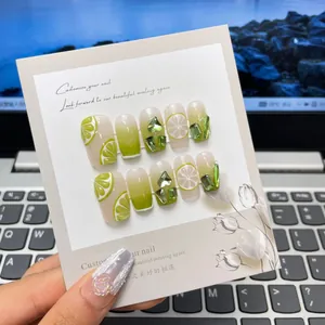 Uñas postizas artesanales con degradado verde, diseño de limón y pedrería 3D elegante