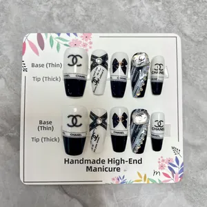 Detail showing hand-made black and white press-on nails with rhinestones and chain