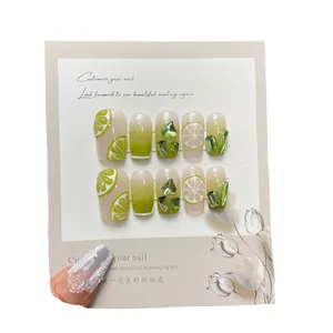 Uñas postizas artesanales con degradado verde lima, cristales de corazón y limones