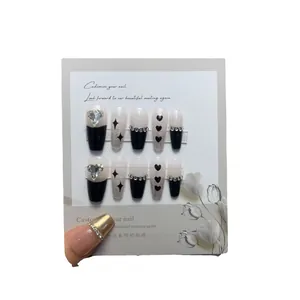 Medium length black and silver press-on nails with heart rhinestones and chain details