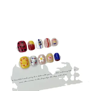 Artistic press-on nails set with red polka dots, floral patterns and colorful hand-painted art