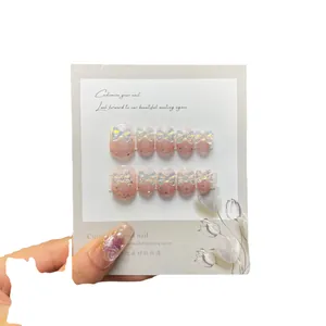 Faux ongles faits main dégradé rose avec papillons 3D et décorations florales