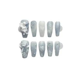 Faux ongles faits main bleu brume avec anges 3D et perles, forme cercueil longue