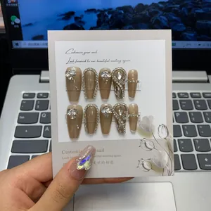 Gros plan sur des ongles press-on style français avec strass de luxe et perles élégantes