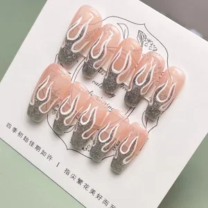 Detail of long ballerina press-on nails with silver glitter flames on pink base