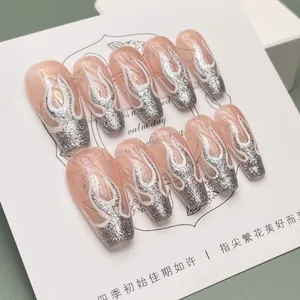 Macro detail of long ballerina nails with silver glitter tips and white flame patterns