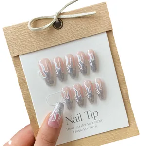Handmade press-on nails featuring pink base, silver glitter, and white flame art design