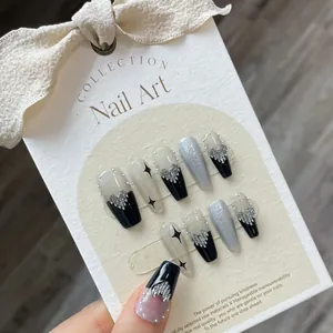 Dark punk style press-on nails featuring silver hearts and black star motifs on display
