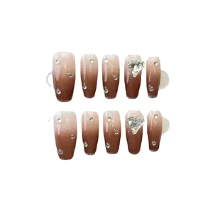 Unghie finte fatte a mano sfumate caramello con cristalli cuore 3D e glitter argento