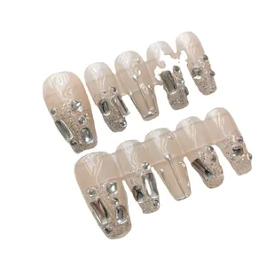 Eleganti unghie finte coffin rosa nude con strass argentati e decori glitter
