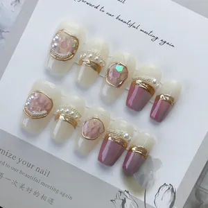Set di unghie fatte a mano con perle e gemme rosa su un'elegante scheda display