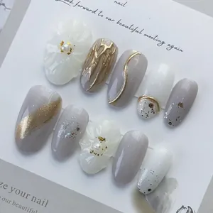Japanese style oval press-on nails with 3D white flower, gold foil, and grey marble art