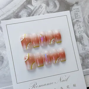 Macro detail of peach gradient press-on nails with lemon art and iridescent glitter