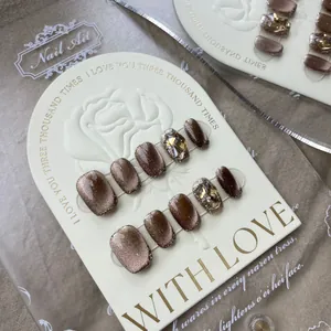 Handmade brown cat eye press-on nails with amber rhinestones and gold glitter accents