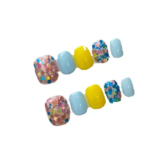 Faux ongles d'orteils faits main en jaune et bleu avec des paillettes multicolores