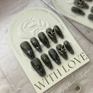 Handmade gunmetal butterfly press-on nails with dark grey marble texture and rhinestones