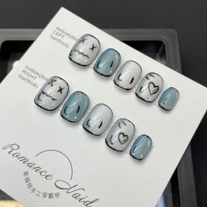 Handmade Y2K comic style press-on nails in grey-blue with hand-painted heart patterns