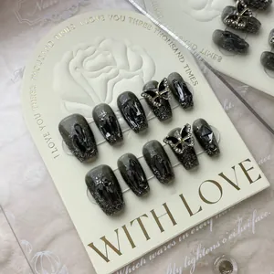 Handmade press-on nails with dark marble texture and 3D black butterfly charms