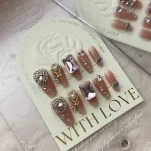 Detail of handmade press-on nails with luxury pink rhinestones and 3D crystal bows