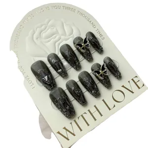 Handmade press-on nails with dark grey glitter base and punk 3D butterfly crystal accents