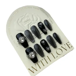 Handmade black cat eye press-on nails with silver glitter and 3D heart rhinestone accents