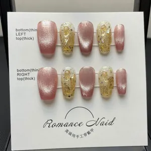 Detail view of pink cat-eye and gold glitter handmade press-on nails on a display board