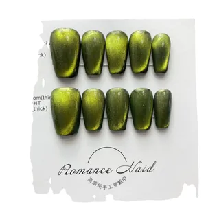 Dreamy olive green cat eye press-on nails in long coffin shape on a display card