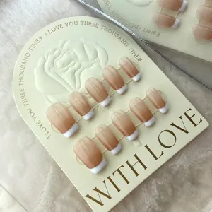 Faux ongles faits main ballerine dégradé french avec bouts blancs brillants sur fond peluche