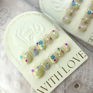 Handmade press-on nails set with star patterns and colorful rhinestones on short oval tips