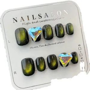 Dark green cat-eye handmade press-on nails with shimmering gold glitter and heart gems