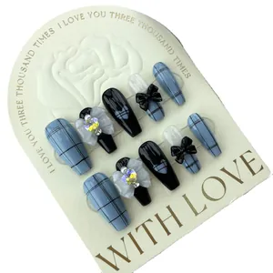 Unghie finte artigianali a quadri blu con fiocco nero e strass a cuore su forma ballerina lunga