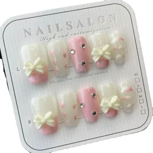 Handgefertigte Press-on Nails mit rosa Schleifen und handgemalten Herzen auf Karte