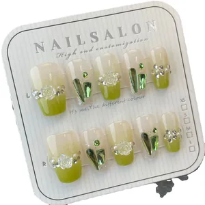 Handmade mint green press-on nails with 3D white roses and emerald crystals