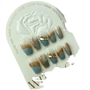 Handmade caramel marble press-on nails with blue accents and gold foil decorations