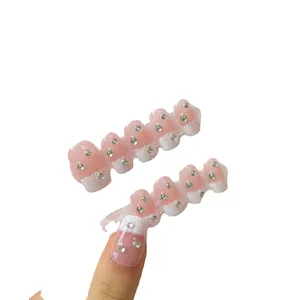 Pink French tips press-on nails with silver rhinestones on a white background