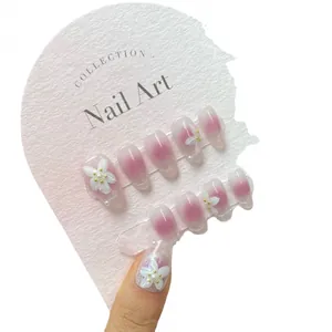 Pink blush gradient press-on nails with 3D white flowers and pearl accents
