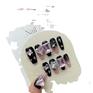 Faux ongles faits main dégradé noir et rose avec strass en cœur et breloques papillon
