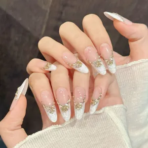 Faux ongles faits main dégradé rose nude, forme amande avec charmes papillon dorés