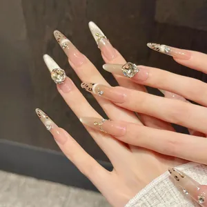 Detail of maple syrup leopard print stiletto press-on nails with rhinestones and cat-eye finish