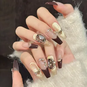 Détails d'ongles faits main œil de chat marron foncé avec strass de luxe et billes dorées